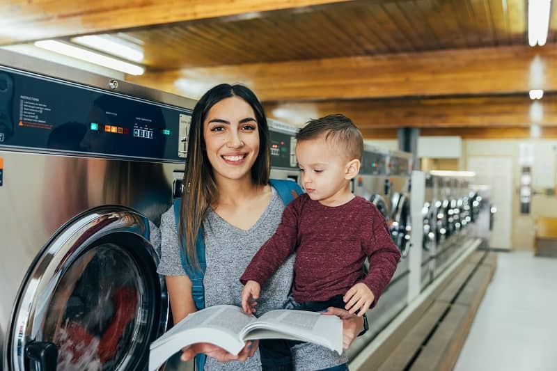 student parent reading at laundromat with son cm 1