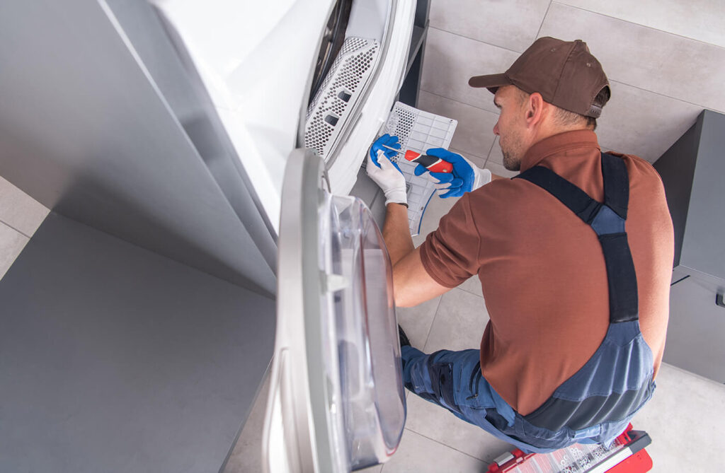 Man repairing washing machine equipment.